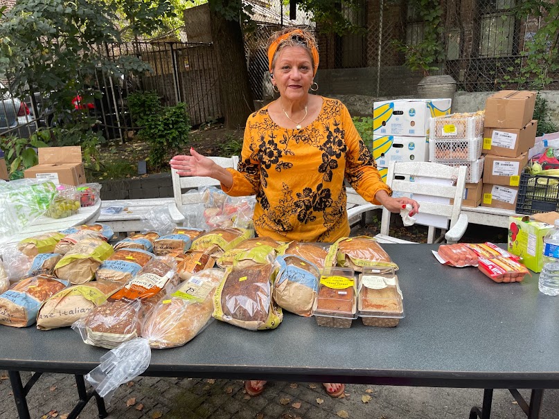 Volunteer presenting bread and pantry staples prepared for pickup